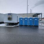 Office trailer with public water system installed at Michigan job site and Porta Johns outside